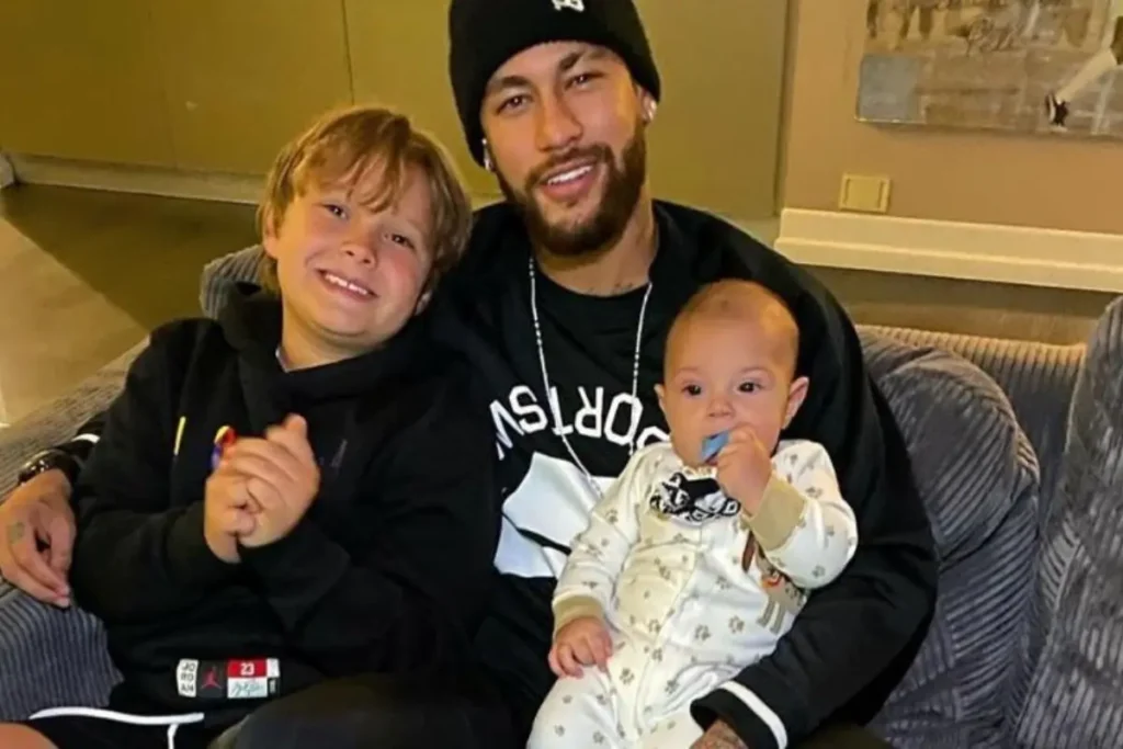 neymar e os filhos sentados no sofa